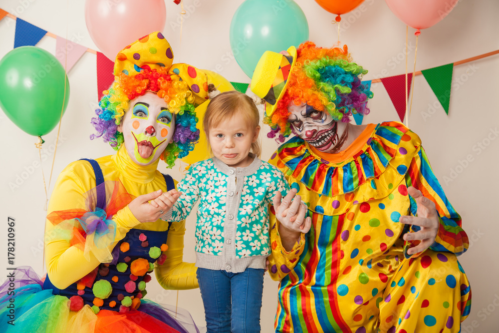 a terrible clown and a good clown with a child. Halloween. The crazy clown and clowness. Little girl a terrible clown and a good clown with a child. Halloween. The crazy clown and clowness. Little girl