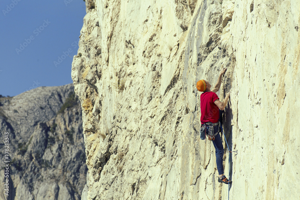 The climber climbs to the top of the mountain.