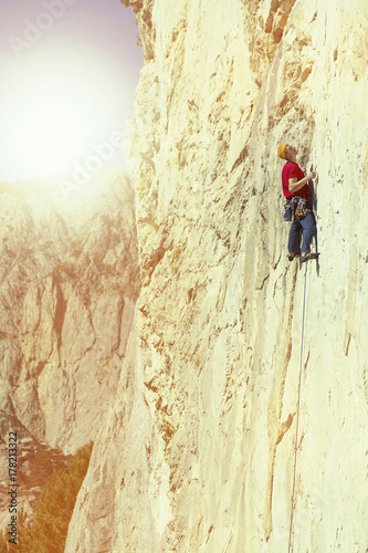 The climber climbs to the top of the mountain.