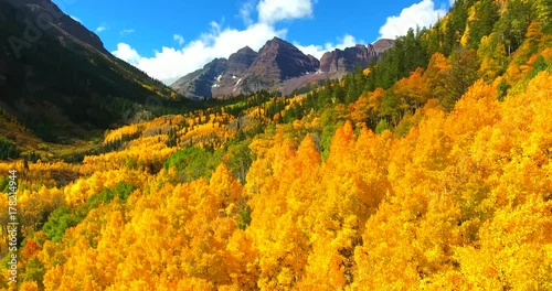 Yellow Fall Foliage With Maroon Bells Mountains In Background - Approaching Aerial Shot - Colorado, USA