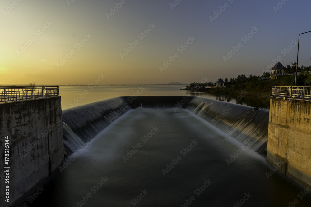 Water from Dam Spillway with Water Pouring. beautiful golden sunset/sun rise on dam the in thailand