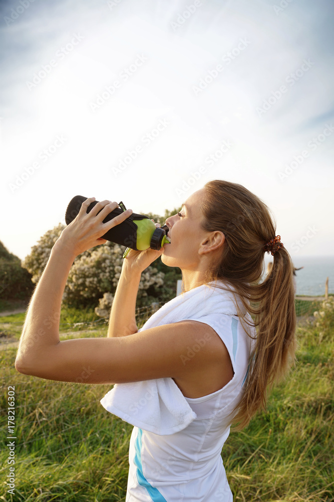 Portrait of fitness girl drinking water from bottle on jogging session Portrait of fitness girl drinking water from bottle on jogging session