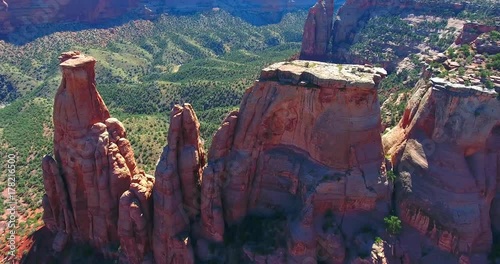 Red Rock Buttes In Desert Canyon With Green Pines - Colorado National Monument