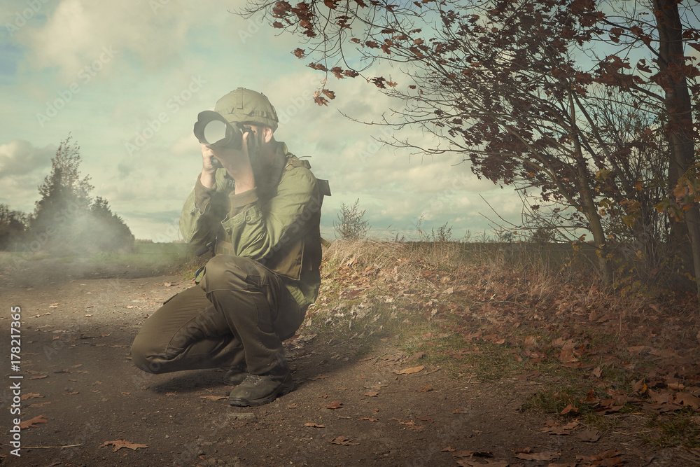 Photographer in war conflict field zone shooting photos
