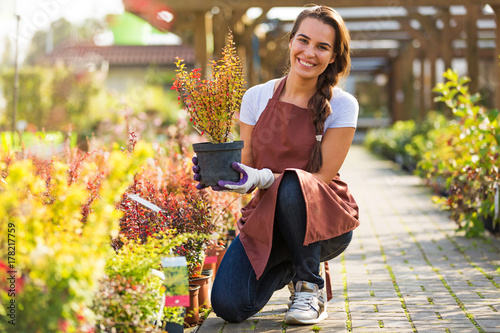 Billede på lærred Smiling employee in garden center