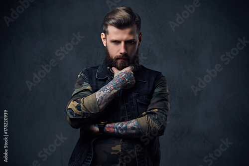 Portrait of bearded tattooed hipster male dressed in a military  © Fxquadro