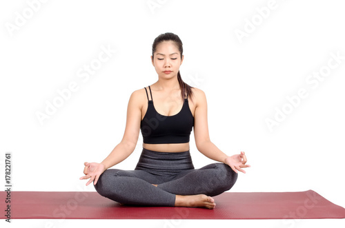 young asian woman doing yoga in Padmasana or Lotus yoga pose on the mat isolated on white background, exercise fitness, sport training, healthy lifestyle concept