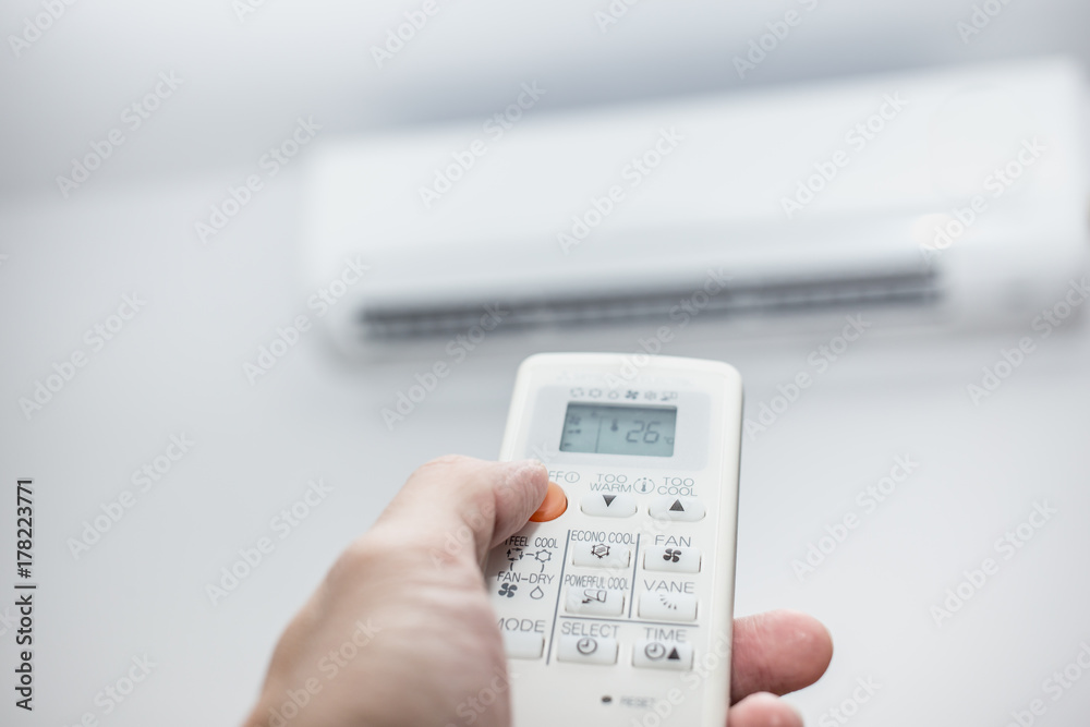 air conditioner closeup hand with remote control air conditioner closeup hand with remote control