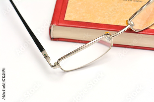 Glasses and book on white background