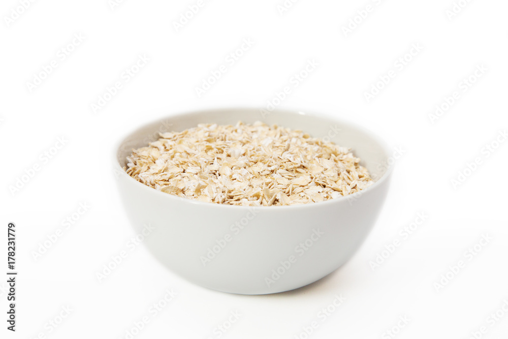 oat flakes in a white bowl on a white background oat flakes in a white bowl on a white background