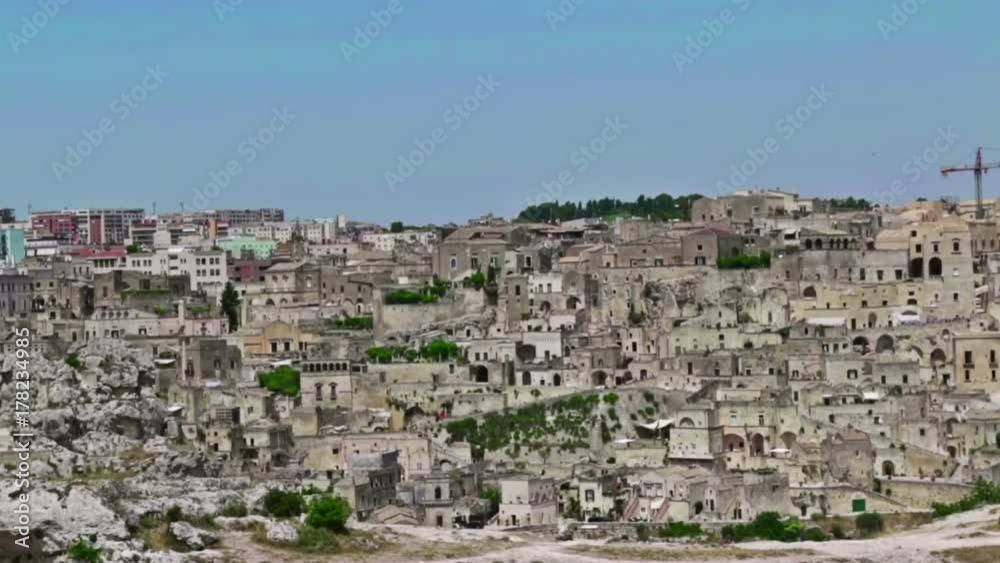 panoramic view of typical stones Sassi di Matera and church of Matera under blue sky. Basilicata, Italy, dolly camera movement panoramic view of typical stones Sassi di Matera and church of Matera under blue sky. Basilicata, Italy, dolly camera movement