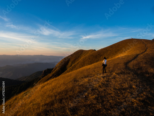 The girl standing alone with the nice yellow mountain range on the back, Chiangmai, Thailand.
