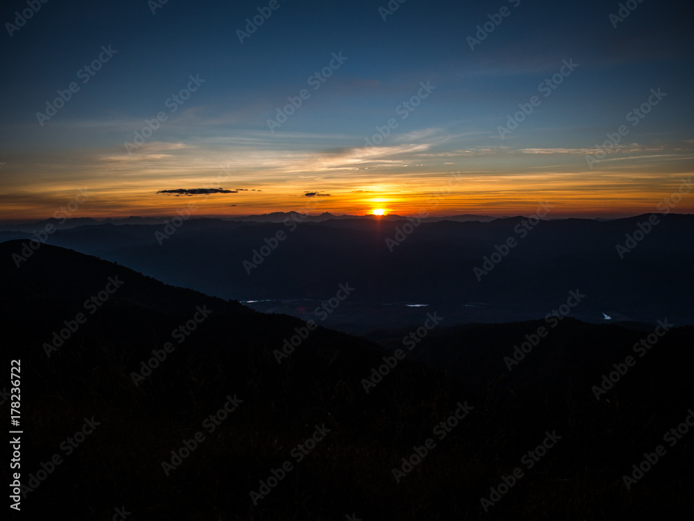 The sun is setting in the far away behind the mountain range in Chiangmai, Thailand. The sun is setting in the far away behind the mountain range in Chiangmai, Thailand.