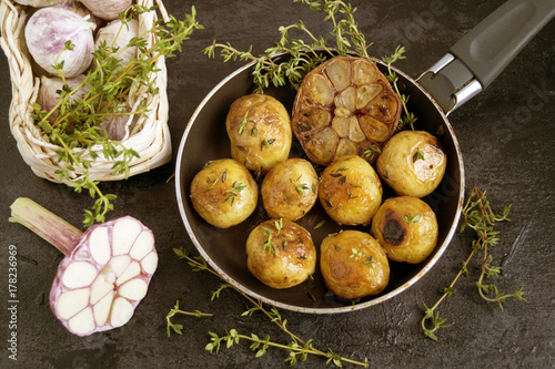 Fried potatoes in a pan with garlic and thyme.