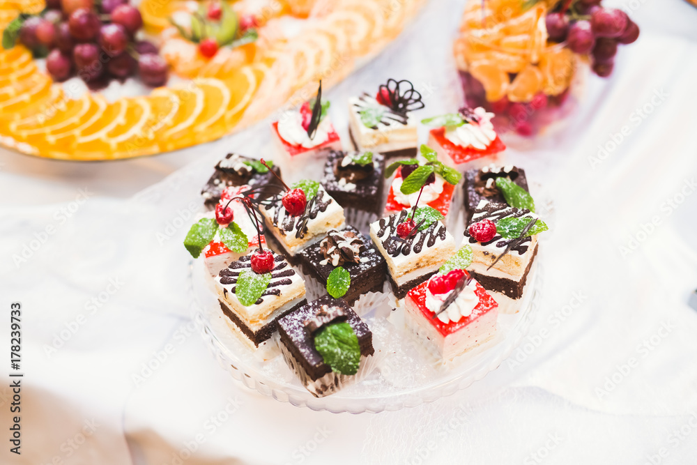Obraz premium Delicious and tasty dessert table with cupcakes shots at reception closeup