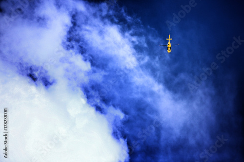 Yellow rescue helicopter in deep blue sky background