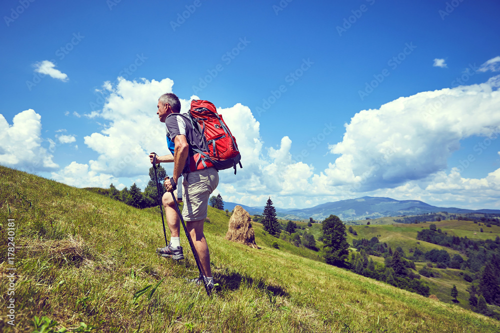 Hiking in the mountains in the summer with a backpack.