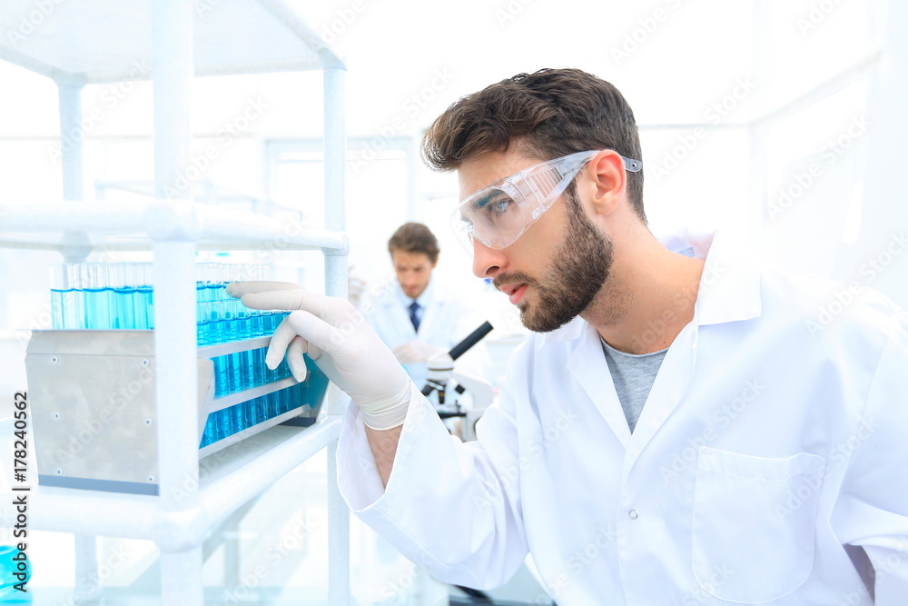 A young man doing an experiment in a chemical laboratory A young man doing an experiment in a chemical laboratory
