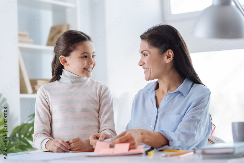 Cheerful delighted woman looking at her daughter Cheerful delighted woman looking at her daughter