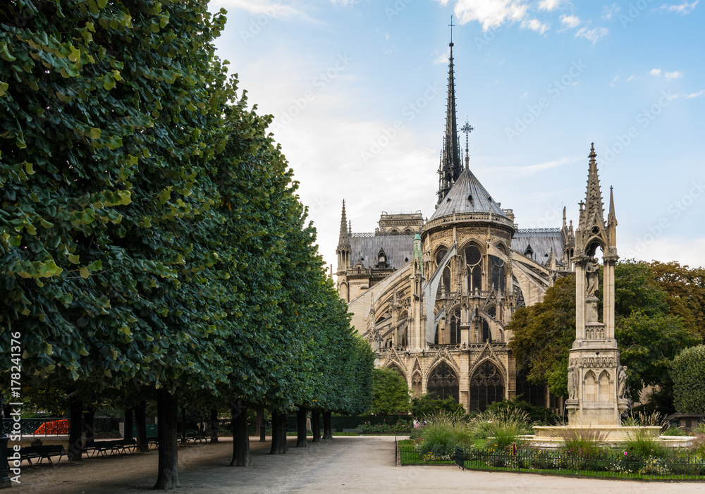 View of the East-end of the Notre-Dame de Paris cathedral in the morning with the fountain of the Virgin in the foreground.