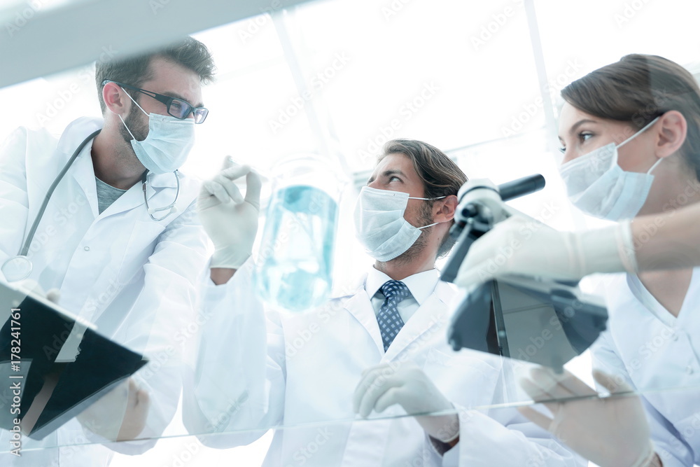 young scientists working with a microscope and test tubes young scientists working with a microscope and test tubes