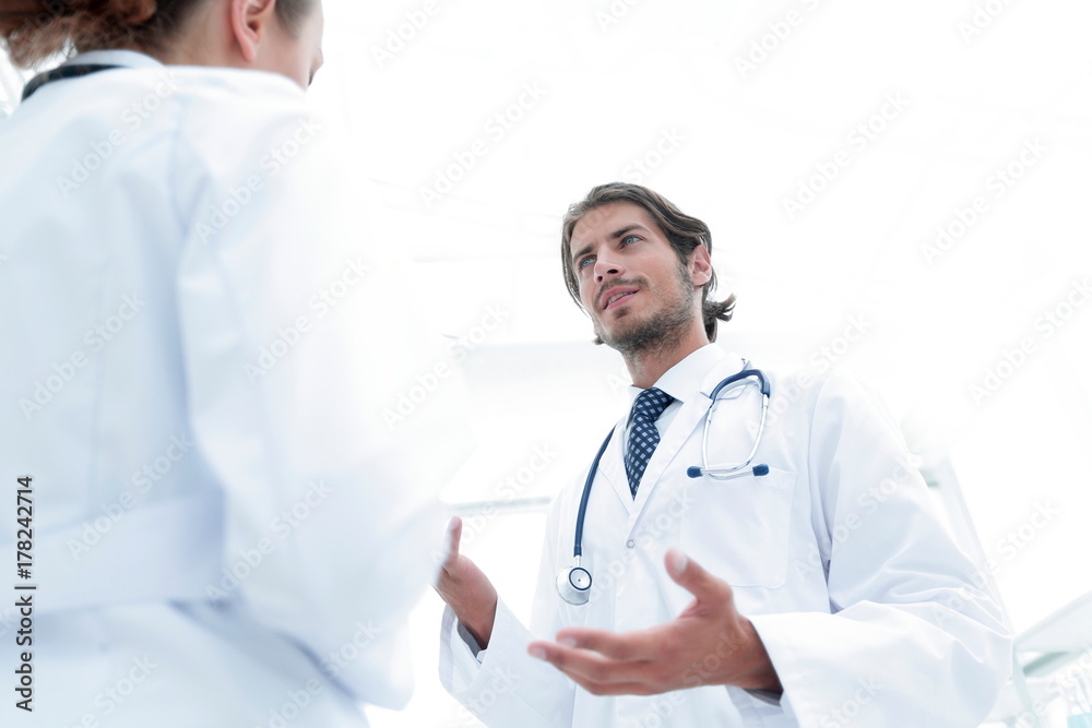 Two Doctors Having Meeting In Hospital Reception Area