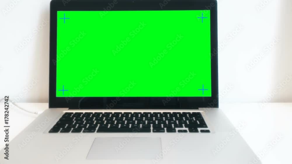Green Screen Laptop Computer On Desktop, Panning Shot. A green screen laptop computer on the