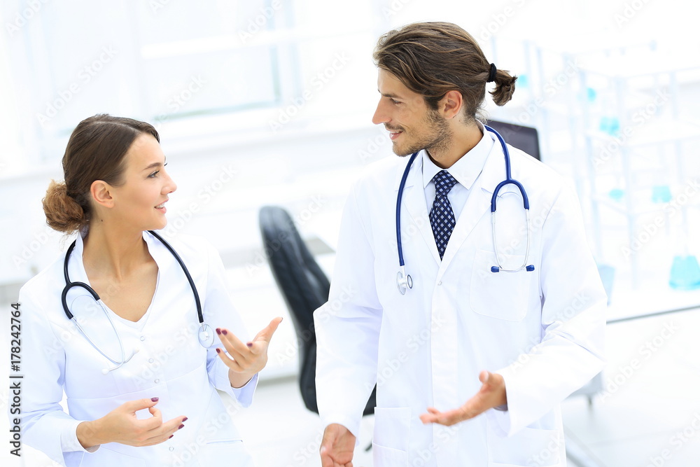Two Doctors Having Meeting In Hospital Reception Area Two Doctors Having Meeting In Hospital Reception Area