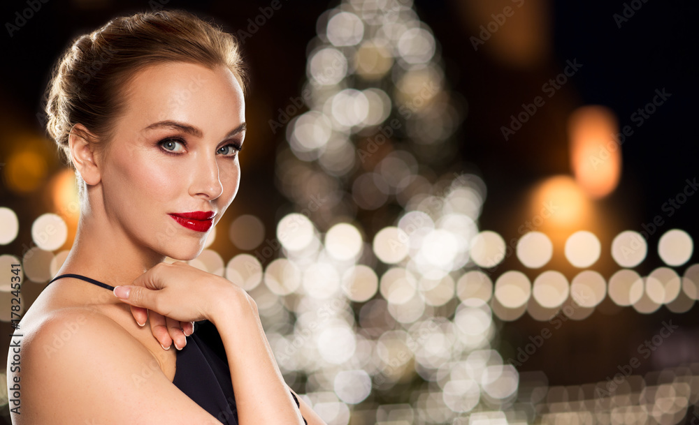 beautiful woman over christmas tree lights