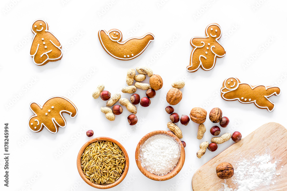 Healthy food for sportsman. Cookies in shape of yoga asanas near nuts on white background top view Healthy food for sportsman. Cookies in shape of yoga asanas near nuts on white background top view