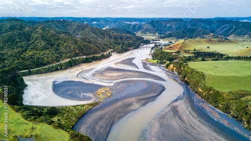 Aerial view on a bridge crossing a river running through mountain valley. Taranaki Region, New Zealand