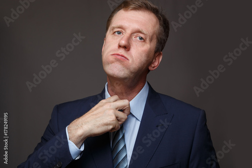 A man tries to loosen a knot on his tie