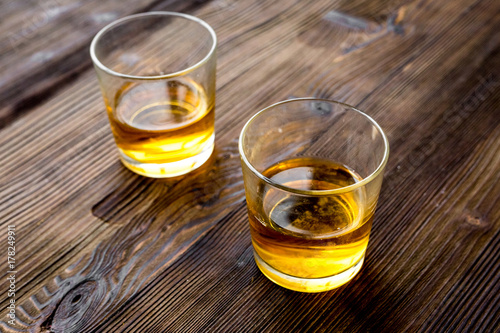 Glasses of whiskey on rustic wooden background