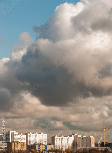 Sunlit buildings under a huge cloud photo