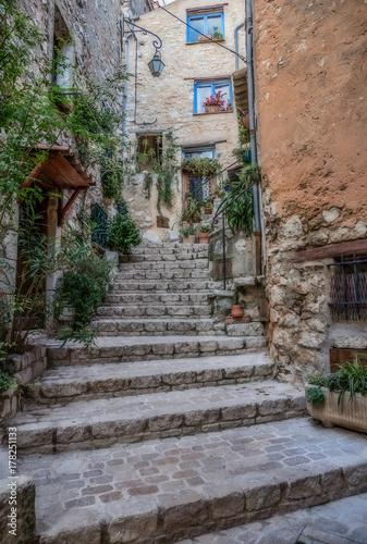 Narrow cobbled street with flowers in the old village Tourrettes-sur-Loup   France.