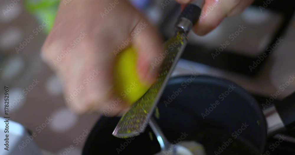 Lemon zest grated into small black saucepan slow motion Lemon zest grated into small black saucepan slow motion
