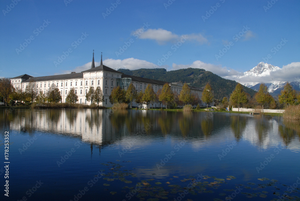 Reflection of Admont Abbey (Stift Admont) and mountains with snow on top in a lake Reflection of Admont Abbey (Stift Admont) and mountains with snow on top in a lake