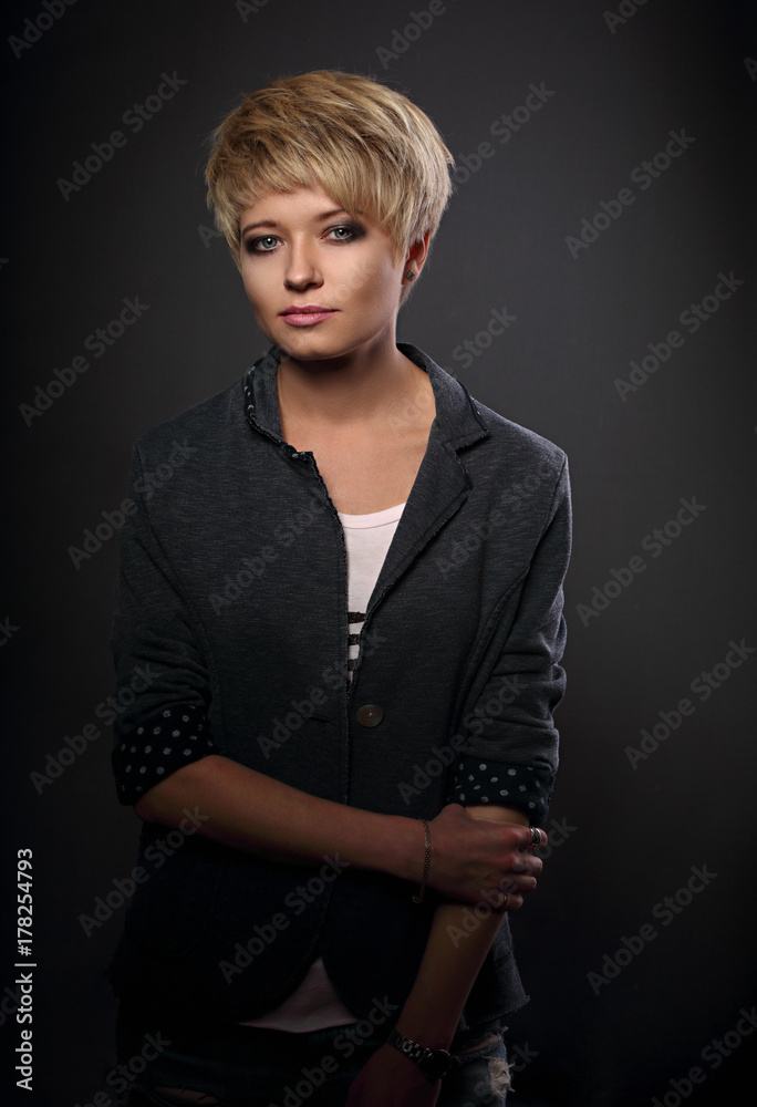 Beautiful serious sexy woman with short bob blond hairstyle in suit on grey background. Closeup portrait Beautiful serious sexy woman with short bob blond hairstyle in suit on grey background. Closeup portrait