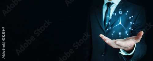 Businessman holding clock. Business time management. photo