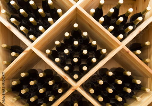 stacked bottles of grape wine in a wine cellar