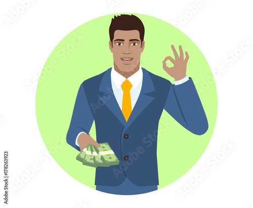 Businessman with money showing a okay hand sign