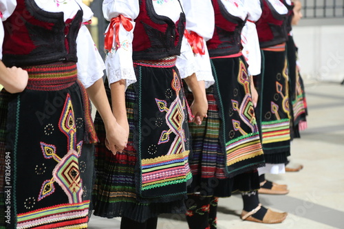 Serbian girls in traditional costume dancing photo