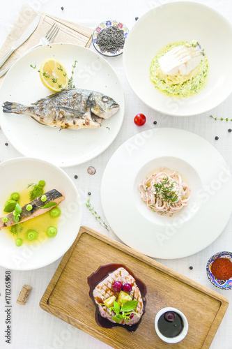 Wallpaper Mural a lot of fish dishes on white table. Top view Torontodigital.ca