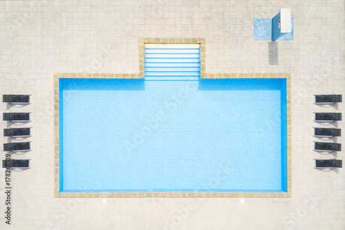 Aerial view of empty swimming pool with shower outdoors. Beautiful pool with clear water as texture background concept. Top view.