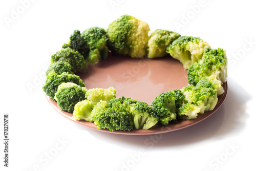 Broccoli on plate isolated on white photo