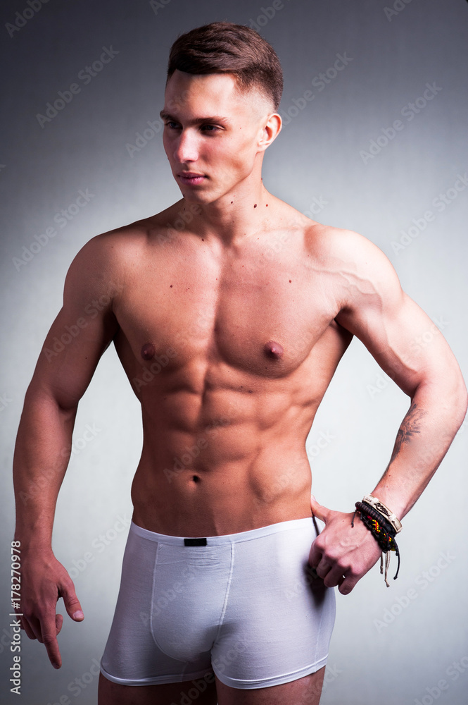 Fototapeta premium Young male athlete on a gray background