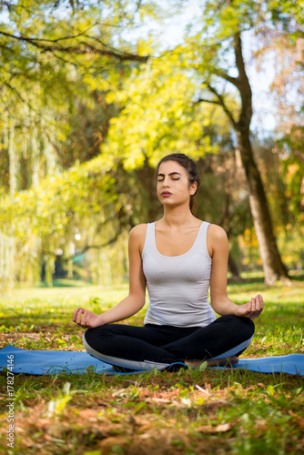Young beautiful woman practicing yoga in the park.