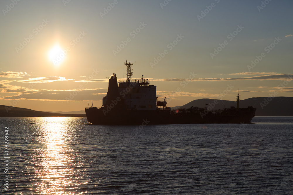 Vessel in the sea against a sunset