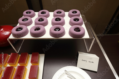 Blueberry cupcake purple round one bite cake with berry inside. Grand Dessert Buffet in Luxury Restaurant Hotel