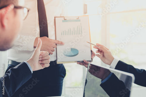 Business team during meeting conference are working documents about the marketing plan and sales profit finance of the company with laptop computer and smartphone tablet on work table
